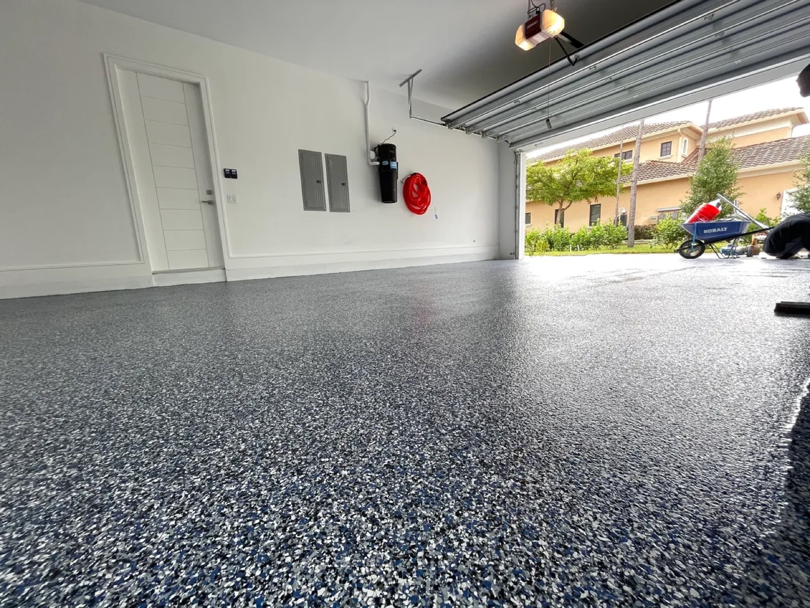 Garage with a gray, black, and white decorative flake floor