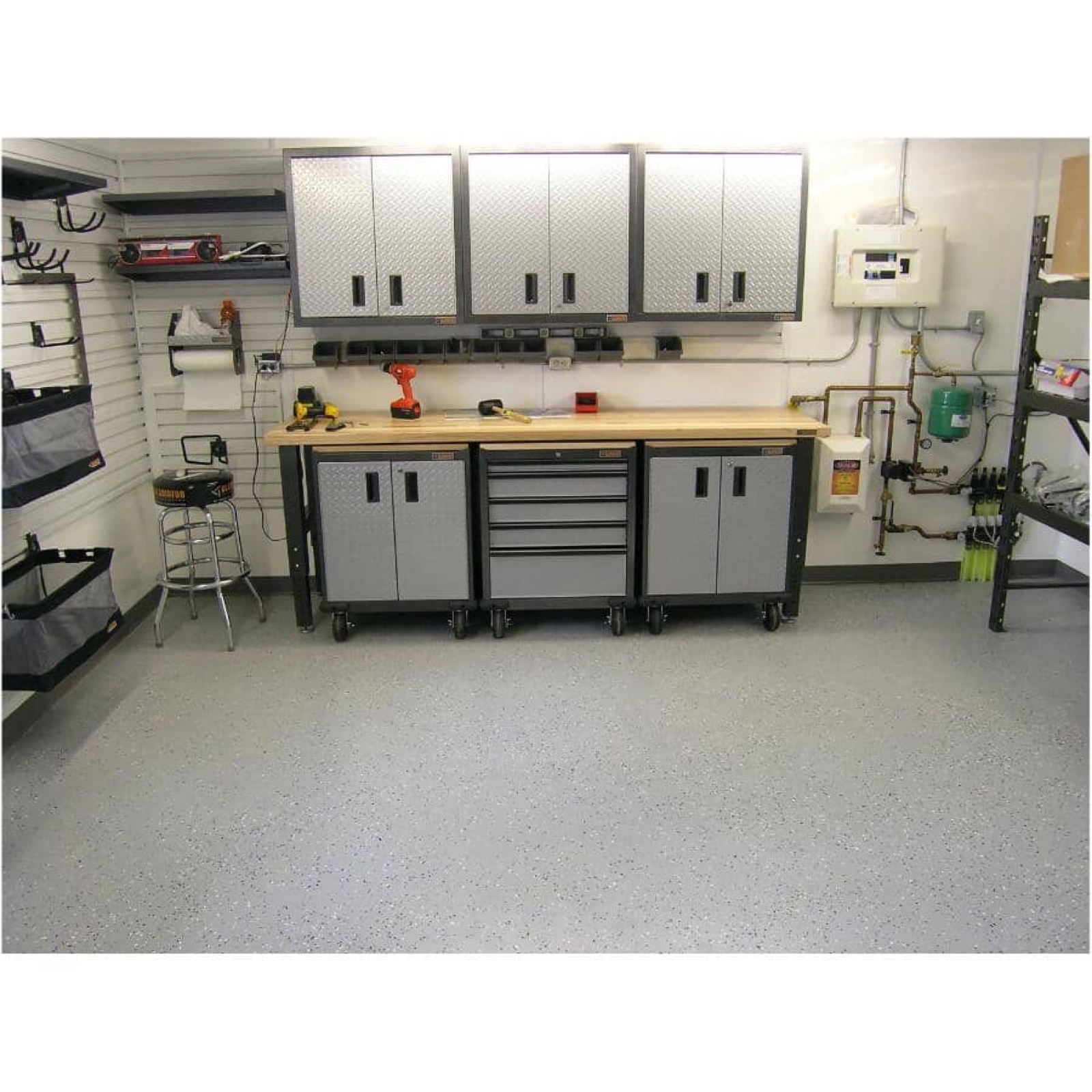 Workshop with gray coated flooring, workbench, and metal cabinets